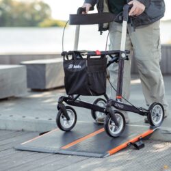 Person using a Gepard rollator on a ramp in an outdoor setting.
