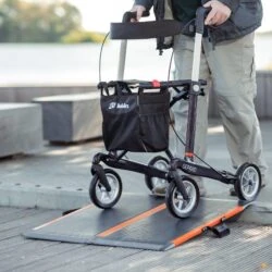 Person using a Gepard rollator on a ramp in an outdoor setting.