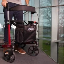 Person using a Mobilex Leopard rollator with a red frame indoors.