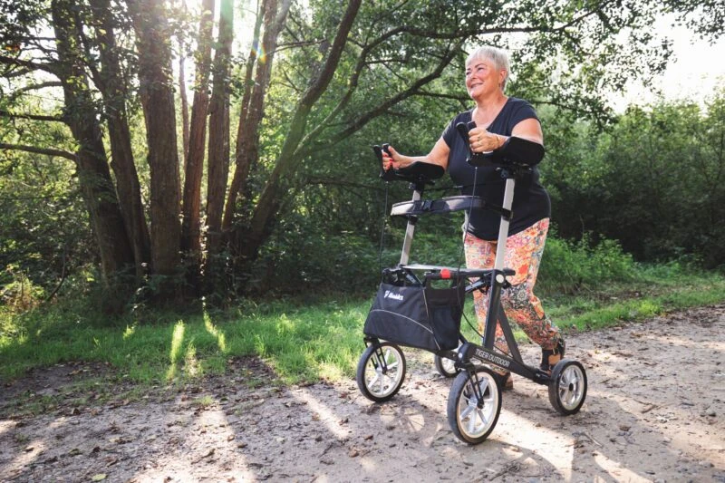 Person using Mobilex Tiger Outdoor Rollator on a forest path.