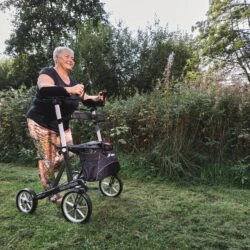 Person using the Mobilex Tiger Outdoor Rollator on a grassy path.