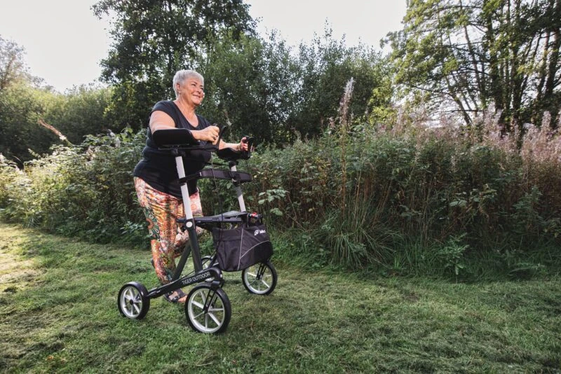 Person using the Mobilex Tiger Outdoor Rollator on a grassy path.