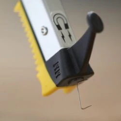 Close-up of the tip of a grabber reacher with a magnet symbol.