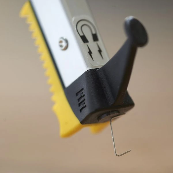Close-up of the tip of a grabber reacher with a magnet symbol.