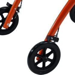 Close-up view of the wheels on an orange indoor rollator.