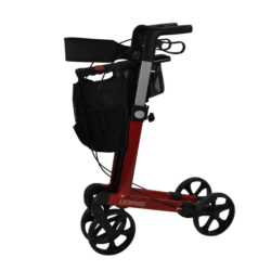 Side view of a red rollator with black wheels and a shopping bag.