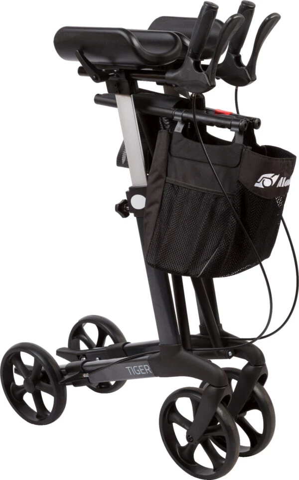 Folded upright rollator with armrests and a black shopping bag.