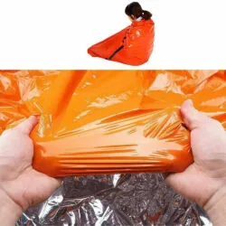 Person wrapped in orange waterproof cover, hands holding the cover.