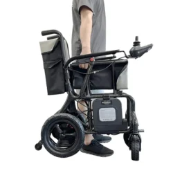 Side view of a folded carbon fiber electric wheelchair being carried.