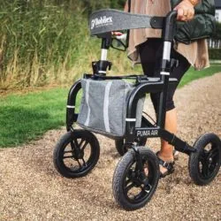 Person using a Mobilex Puma Air rollator on a gravel path.
