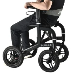Person seated on a Mobilex Puma Air rollator with large wheels.