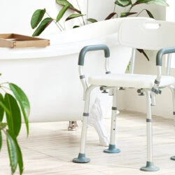 Shower chair with arms and adjustable legs in a bathroom setting.