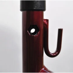 Close-up of a red metal frame with a hook and hole.