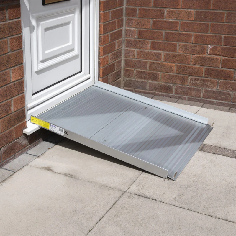 Aluminium rollable ramp placed at a doorway for accessibility.