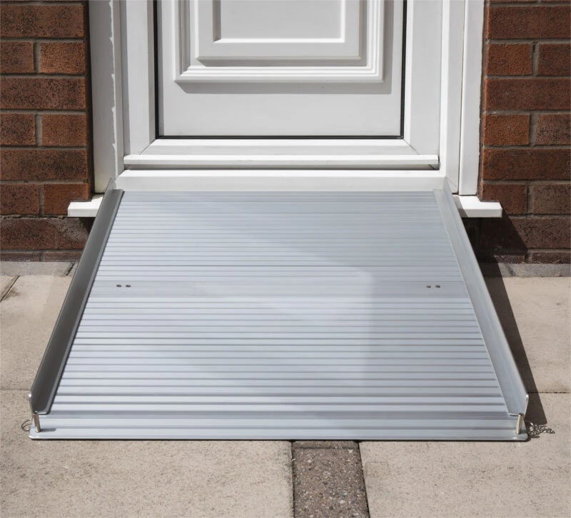 Aluminium rollable ramp placed at a doorstep for accessibility.