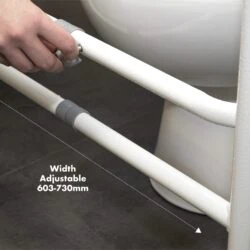 Hand adjusting the width of a toilet support frame next to a toilet.