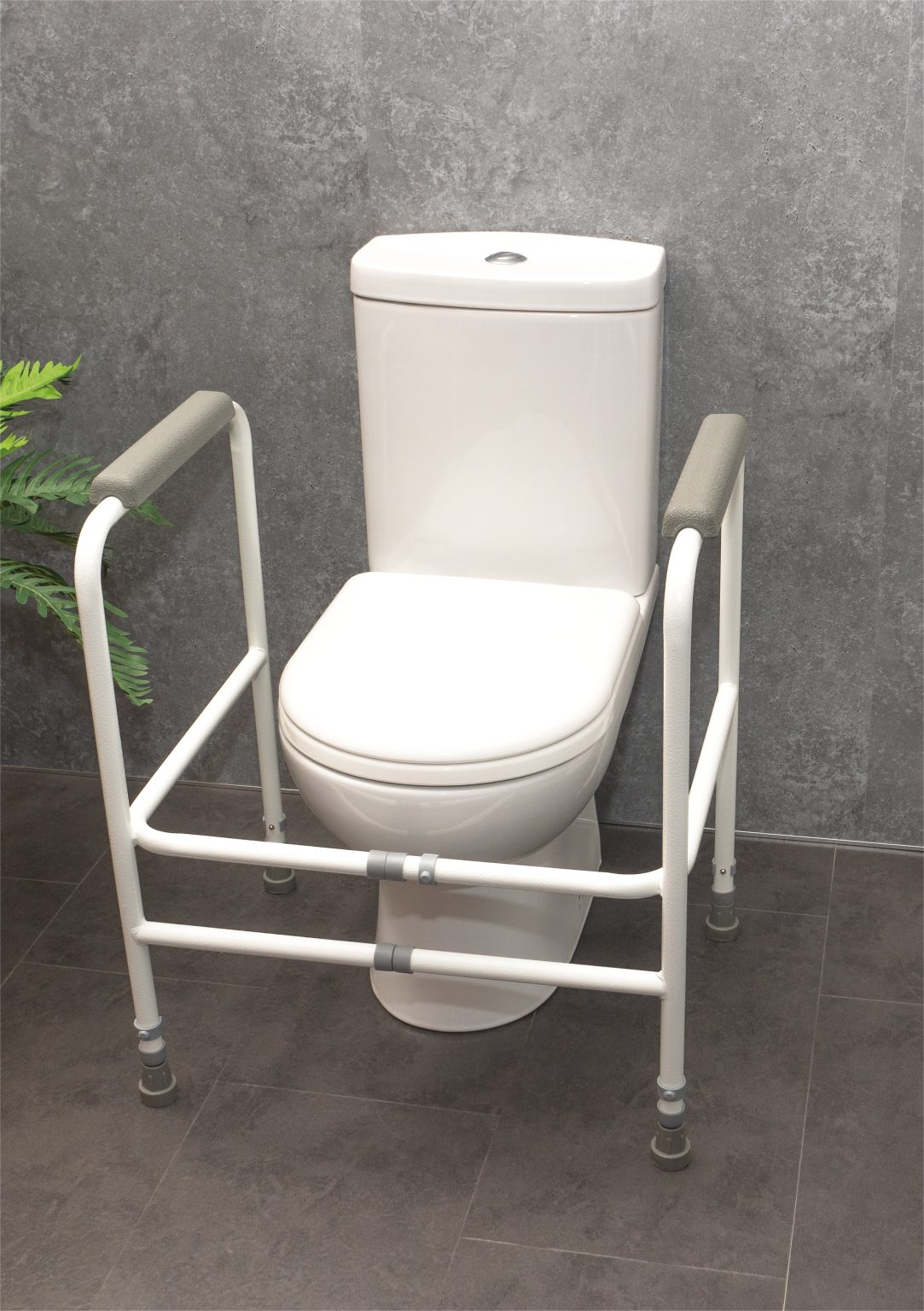 White adjustable toilet support frame around a toilet.