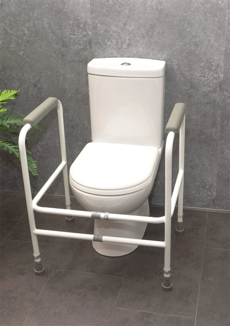 White adjustable toilet support frame around a toilet.