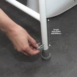 Hand adjusting the height of a toilet support frame leg.