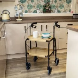Indoor mobility trolley with brakes in a kitchen, holding a mug and bowl.