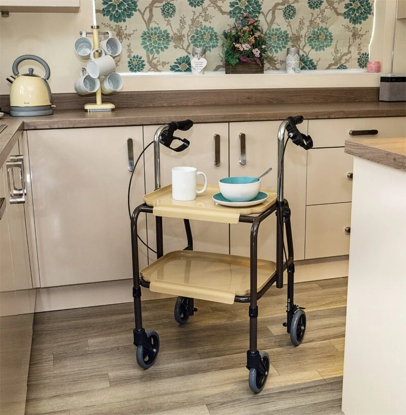 Indoor mobility trolley with brakes in a kitchen, holding a mug and bowl.