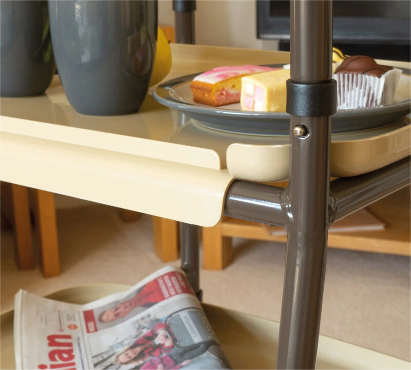Close-up of an indoor trolley with a plate of pastries and a newspaper.