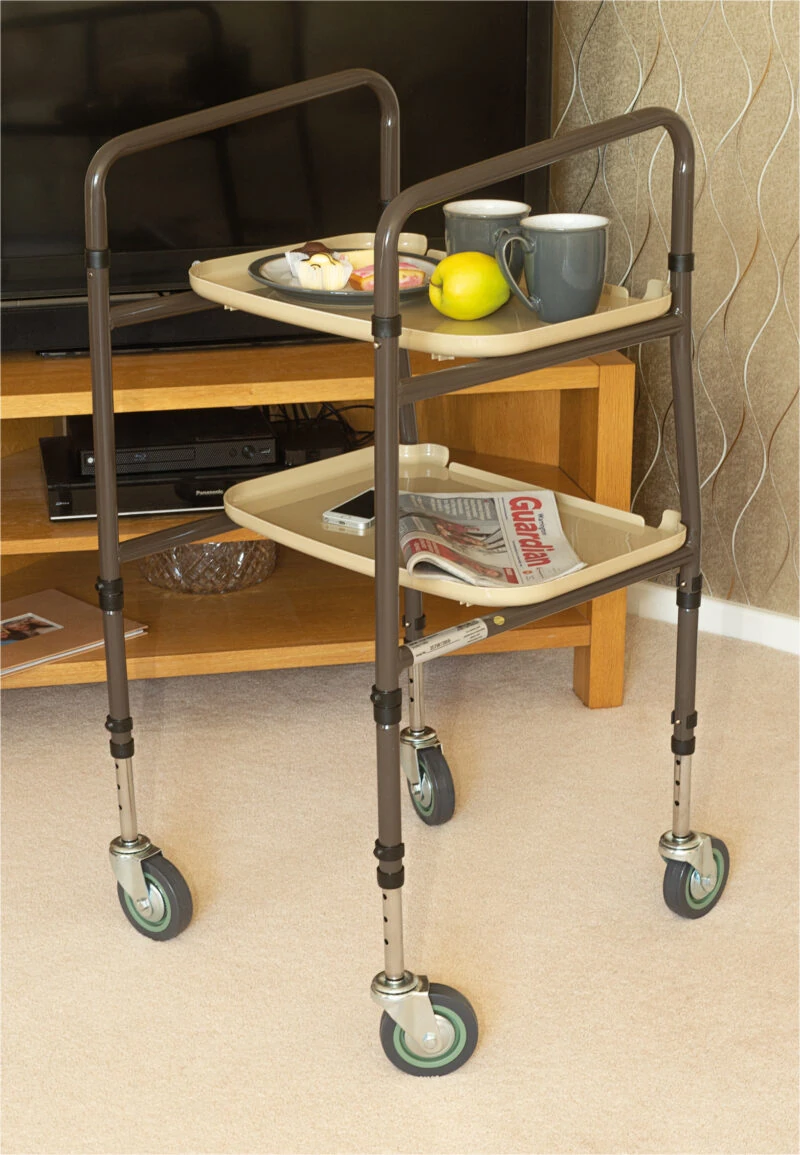 Height adjustable trolley with two trays in a living room setting.