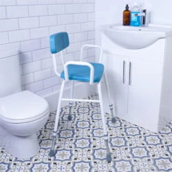 Perching stool with padded back and armrests in a bathroom setting.