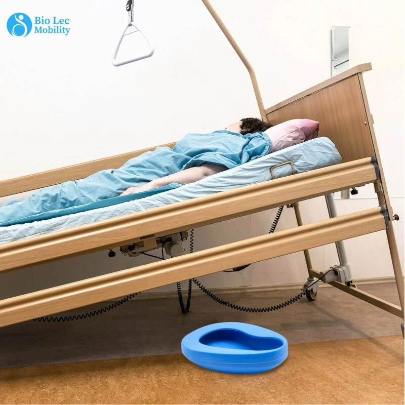 Hospital bed with a patient and a blue bedpan on the floor.