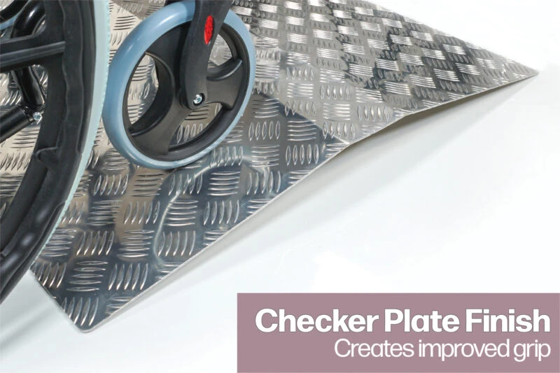 Wheelchair on aluminium ramp with checker plate finish.