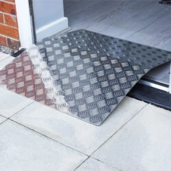 Aluminium bridge ramp placed over a doorway threshold.