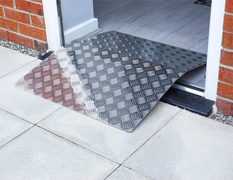 Aluminium bridge ramp placed over a doorway threshold.