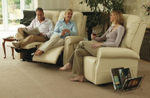 Three people relaxing on cream recliner chairs in a living room.
