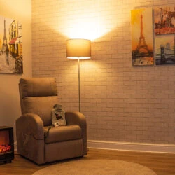 Electric recliner chair in a cozy living room setup with art and a lamp.