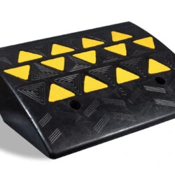 Black rubber kerb ramp with yellow reflective triangles.