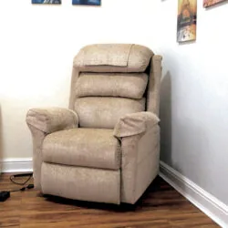 Beige riser recliner armchair in a room with wall art.