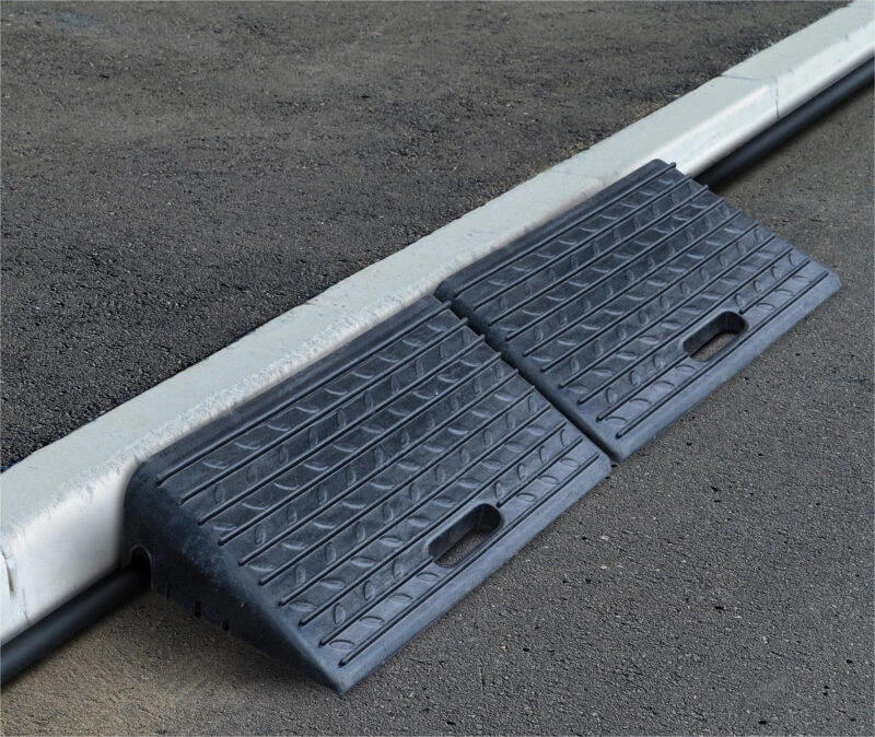 Two rubber threshold ramps placed on a kerb with textured surface.