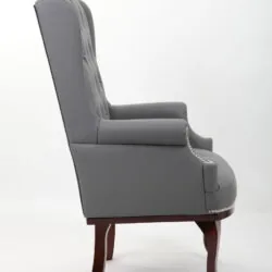 Side view of a grey high back armchair with dark mahogany legs.