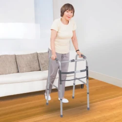 Person using a lightweight folding walking frame indoors.