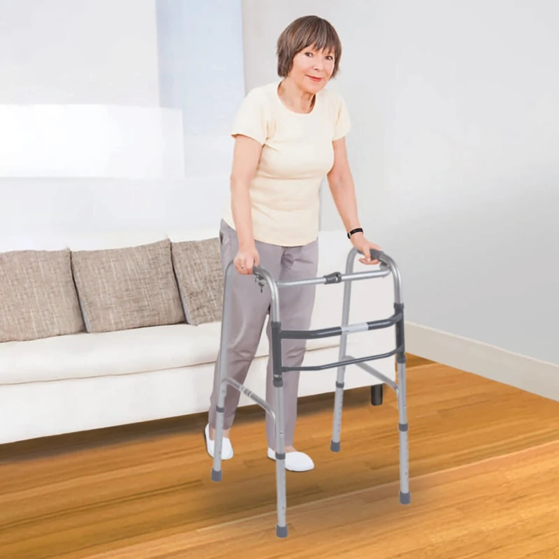 Person using a lightweight folding walking frame indoors.