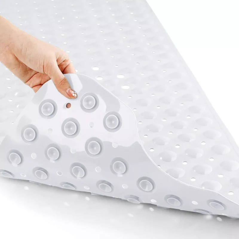 White shower mat being lifted, showing suction cups underneath.