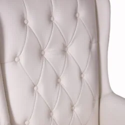 Close-up of a cream tufted armchair backrest.