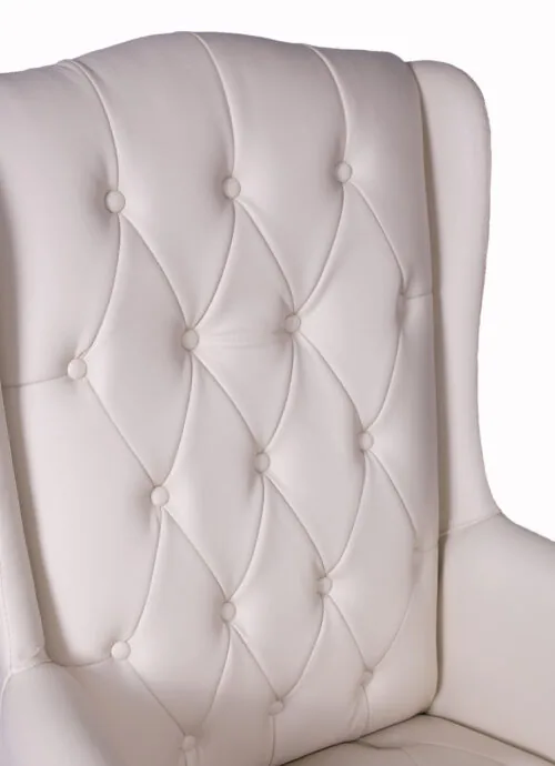 Close-up of a cream tufted armchair backrest.