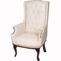 Cream high back armchair with dark mahogany legs and tufted upholstery.