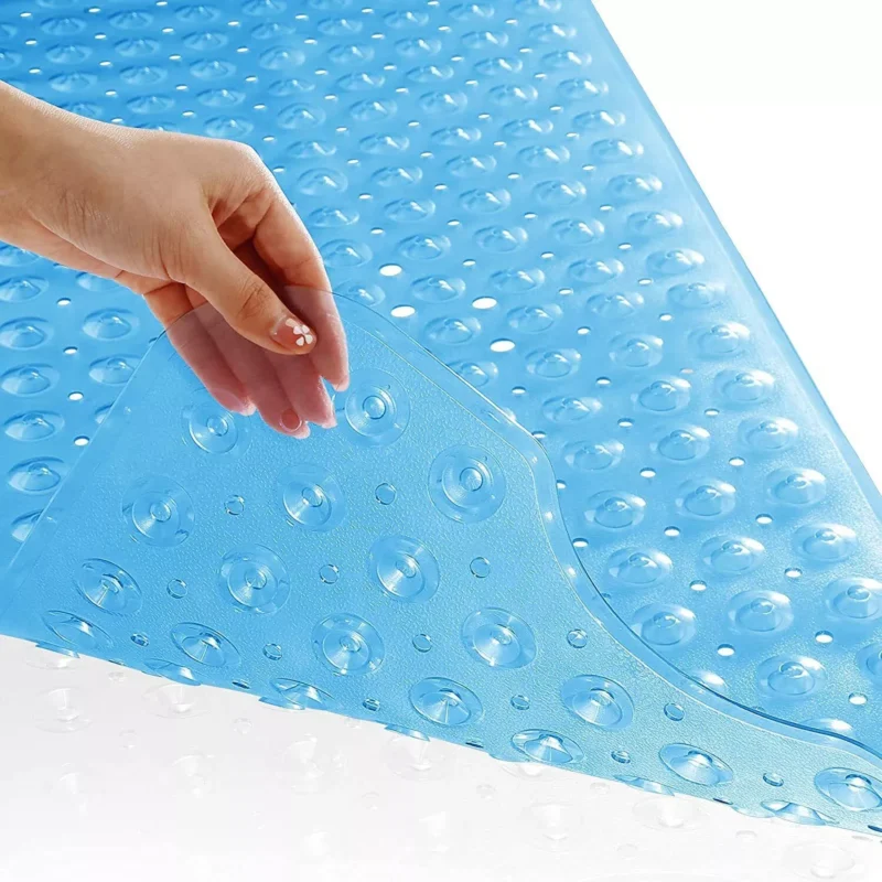 Hand lifting a blue non-slip shower mat with suction cups.