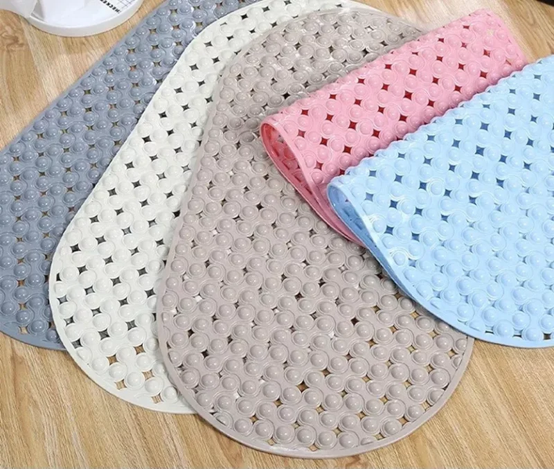 Five non-slip shower mats in various colors on a wooden floor.