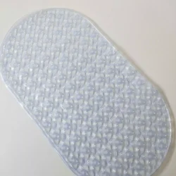 Clear oval shower mat with suction cups on a white surface.