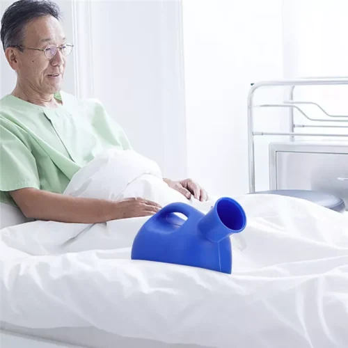 Blue urinal bottle on a bed beside a person in a hospital gown.