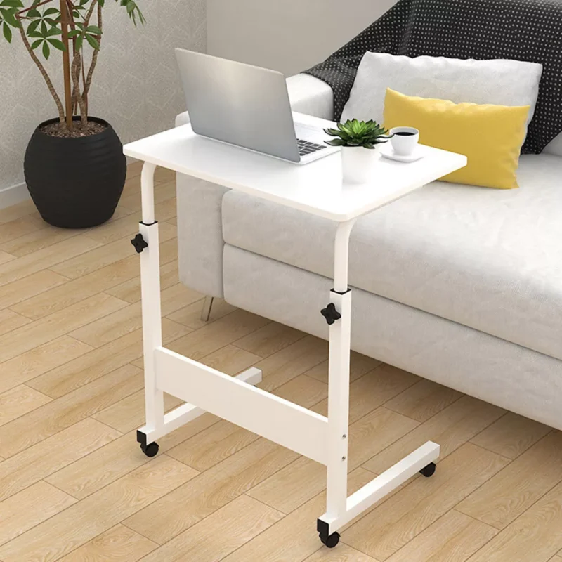 White over chair table with laptop and plant beside a sofa.
