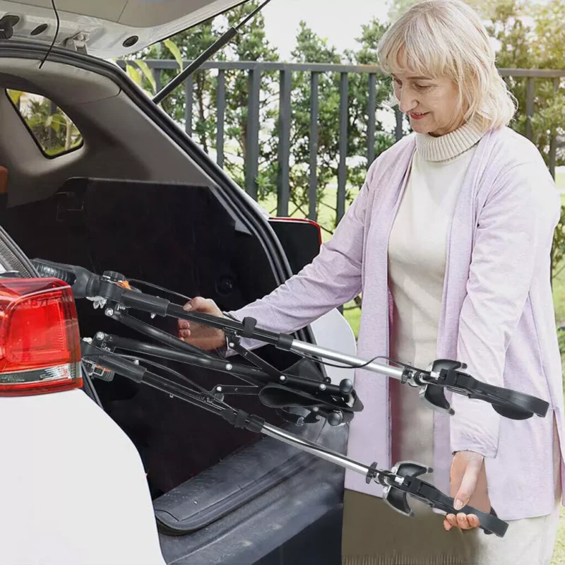 Person placing a folded mobility walker into a car trunk.